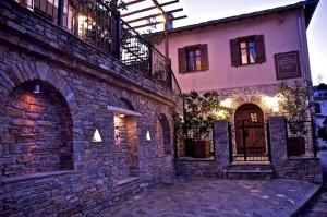 a large brick building with a door on the side of it at Archontiko Papoutsi in Mouresi