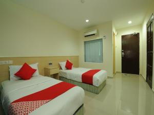 a hotel room with two beds with red pillows at OYO 1055 Batu Caves Star Hotel in Batu Caves