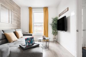 - un salon avec un canapé et une télévision dans l'établissement Apartments Near Montreal Olympic Park, à Montréal