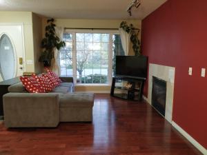 a living room with a couch and a flat screen tv at Brother Li Homestay in Calgary
