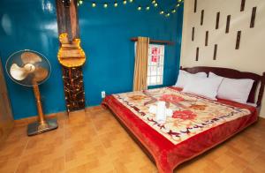 a bedroom with a bed with a candle and a fan at Bình Đào Hotel - Khách sạn ngay trung tâm giá rẻ in Da Lat