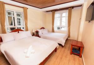 2 letti in una camera con 2 finestre di Bình Đào Hotel - Khách sạn ngay trung tâm giá rẻ a Da Lat