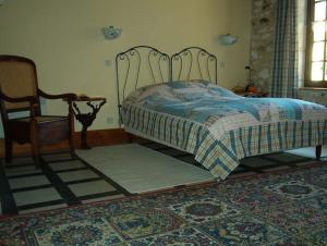 a bedroom with a bed and a chair and a table at Coté Jardin in Villiers-sur-Loir