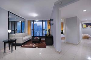 a living room with a couch and a room with a view at Horison Ultima Suite & Residences Rasuna Jakarta in Jakarta