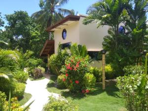 ein Cottage im Garten eines Resorts in der Unterkunft Siargao Sunset Bay Beach Villas in General Luna