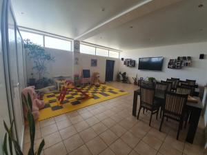 een woonkamer met een tafel en stoelen en een eetkamer bij Guest House Na Mamayke + in Sotsji