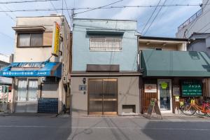a blue building on a city street at Harbor Light Tengachaya in Osaka