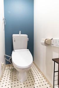 a white toilet in a bathroom with a blue wall at Harbor Light Tengachaya in Osaka +37 photos