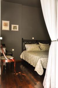 a bedroom with a bed and a chair at Kifissia Naxou Maisonette in Athens