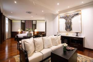a living room with a white couch and a cross on the wall at The Bridge An Eclectic Luxotel in Chiang Mai