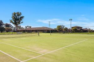 a tennis court with two tennis nets on it at Quality Inn Carriage House in Wagga Wagga