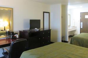 a hotel room with a bedroom with a desk and a bed at Quality Inn Longmont in Longmont