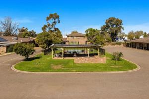 a house with a roundabout in the middle of a street at Quality Inn Carriage House in Wagga Wagga