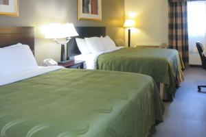 a hotel room with two beds with green sheets at Quality Inn Longmont in Longmont