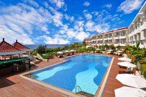 einen Pool in einem Hotel mit Tischen und Sonnenschirmen in der Unterkunft Fullon Resort Kending in Eluan
