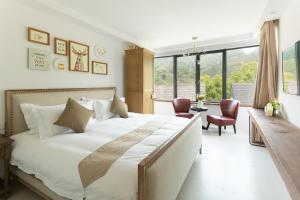 a bedroom with a large bed and a large window at Genichi Villa in Hangzhou