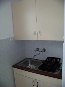 a kitchen sink with a faucet on top of it at Nefelejcs Apartman in Fertőhomok