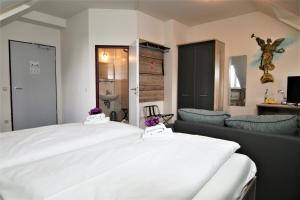 una camera da letto con un grande letto bianco e un divano di Hotel am Waldschlösschen - Brauhaus a Dresda