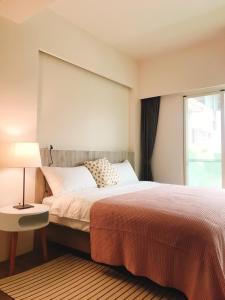 una camera da letto con un letto grande e una finestra di Next door of No 7 Youheng B&B a Città di Hualien