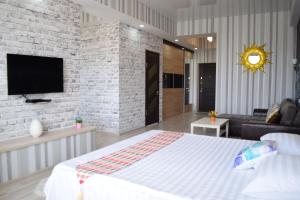 a bedroom with a large bed and a brick wall at FlatRent apartment in Bishkek