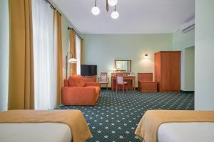 una habitación de hotel con 2 camas y una silla en Hotel Hetman en Varsovia