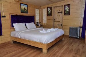 A bed or beds in a room at Snow King Retreat- Himalayan view , Revolving Restaurant , Pinewood Cottages , Huts , Villas , Rooms , Hydro Pool , Karaoke Music , DJ Night