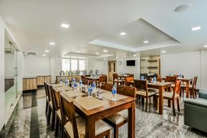 a dining room with wooden tables and chairs at Park Avenue Suites in Coimbatore