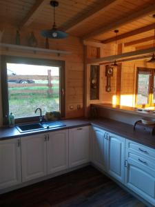 una cocina con fregadero y una ventana en una cabaña en Domek u Charnasia, en Biskupiec