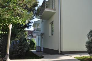 een zijdelings uitzicht op een wit gebouw met bomen bij Villa Dunja in Kragujevac