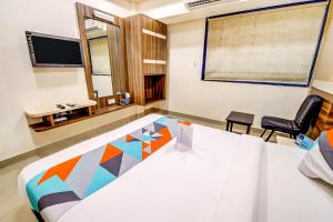 um quarto com uma cama, uma secretária e uma cadeira em Hotel Dreamland em Lonavala