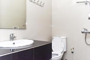 a bathroom with a toilet and a sink and a mirror at RedDoorz near Alun Alun Wonosobo in Wonosobo