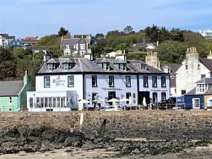 een groot wit gebouw op het strand bij The Harbour House Sea front Hotel in Portpatrick