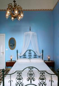 um quarto com uma cama com uma parede azul em 5 Balconi B&B em Catânia