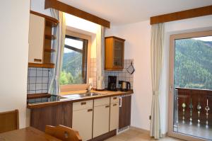 een keuken met een wastafel en een raam bij Haus Kohler Bernhard in Nova Levante