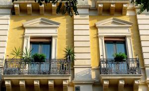 un edificio con tres ventanas con macetas. en 5 Balconi B&B, en Catania