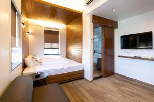 a small bedroom with a bed and a tv at Lychee Sunset Hotel Cheung Chau in Hong Kong