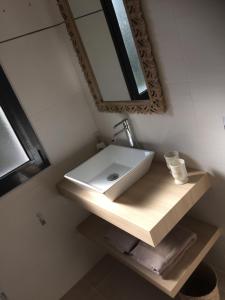 ein Badezimmer mit einem weißen Waschbecken und einem Spiegel in der Unterkunft Chambre kercaves in Larmor-Plage
