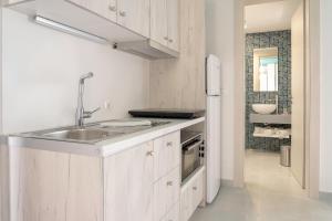 a white kitchen with a sink and a refrigerator at Paradisos in Frangokastello +76 photos