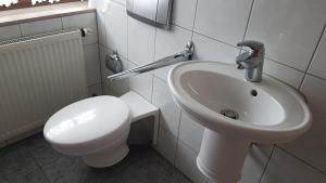 a bathroom with a white toilet and a sink at Gino s Ferienwohnung in Illingen