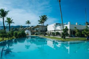 a large swimming pool with palm trees in front of a building at Costa Pacifica Baler in Baler