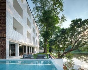 an external view of a building with a swimming pool at Little Shelter Hotel Chiangmai in Chiang Mai