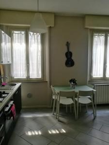 a kitchen with a table and chairs and a guitar on the wall at Casa Eva 2010 in Cremona