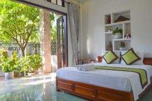 1 dormitorio con cama y ventana grande en HaLo HomeStay, en Hoi An