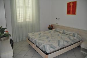 a bedroom with a bed in a white room at Residence Marina in Alassio