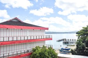 un bâtiment à côté d'une étendue d'eau avec des bateaux dans l'établissement RedDoorz Plus @ Tirta Kencana Hotel, à Ambon