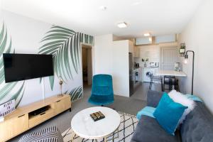a living room with a couch and a tv at Lake Terrace Apartment in Taupo