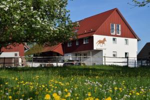 um celeiro com um campo de flores à frente dele em Bachäckerhof - Nichtraucherhotel- em Ravensburg