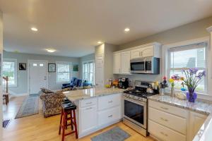a kitchen with white cabinets and a stove top oven at Bella Luna in Falmouth