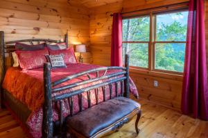 ein Schlafzimmer mit einem Bett und einem Fenster in einem Blockhaus in der Unterkunft 4 Bed 4 Bath Vacation home in Sylva I in Sylva