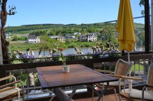 a table on a balcony with a view of a river at Weingut Erbes-Henn in Ürzig +9 photos